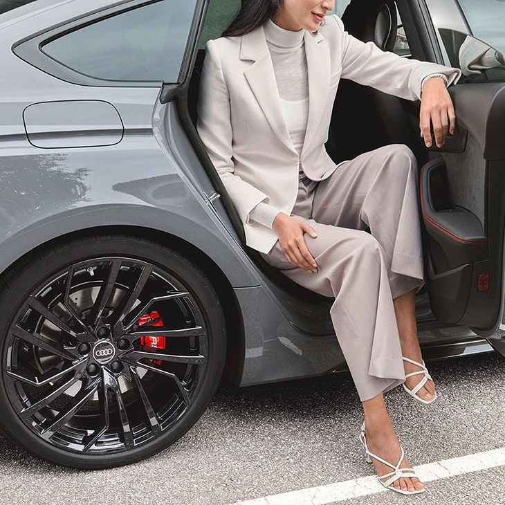 A women is getting out of the back of the Audi RS 5 Sportback